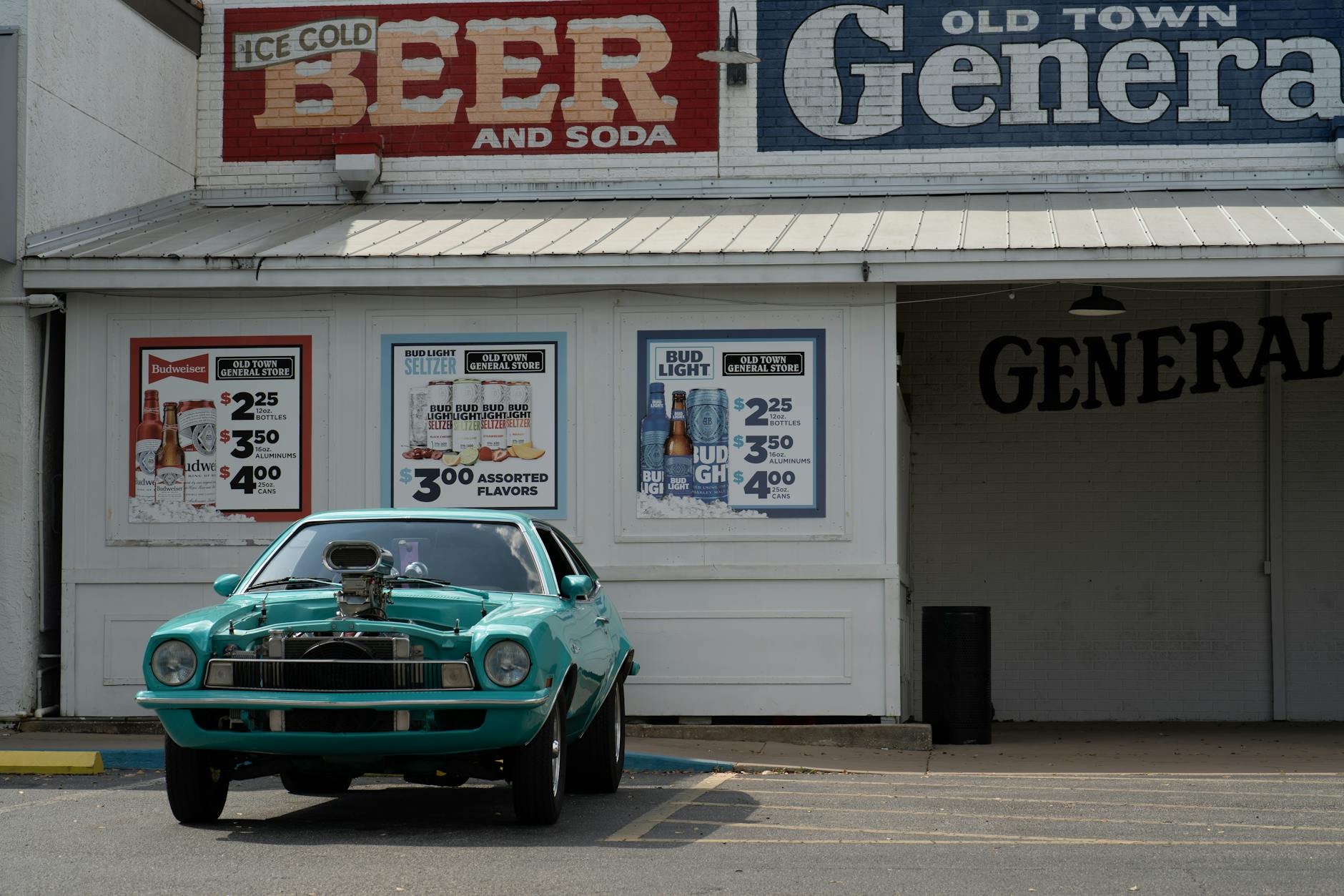 Turkusowy klasyczny samochód przed zabytkowym sklepem z szyldami