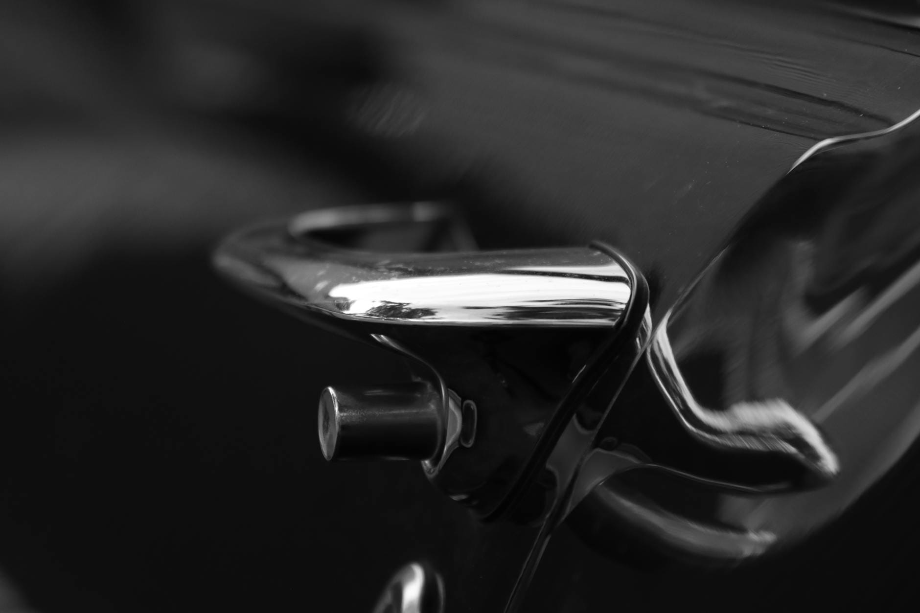 Chromowana klamka drzwi zabytkowego Forda T w czarno-białym ujęciu