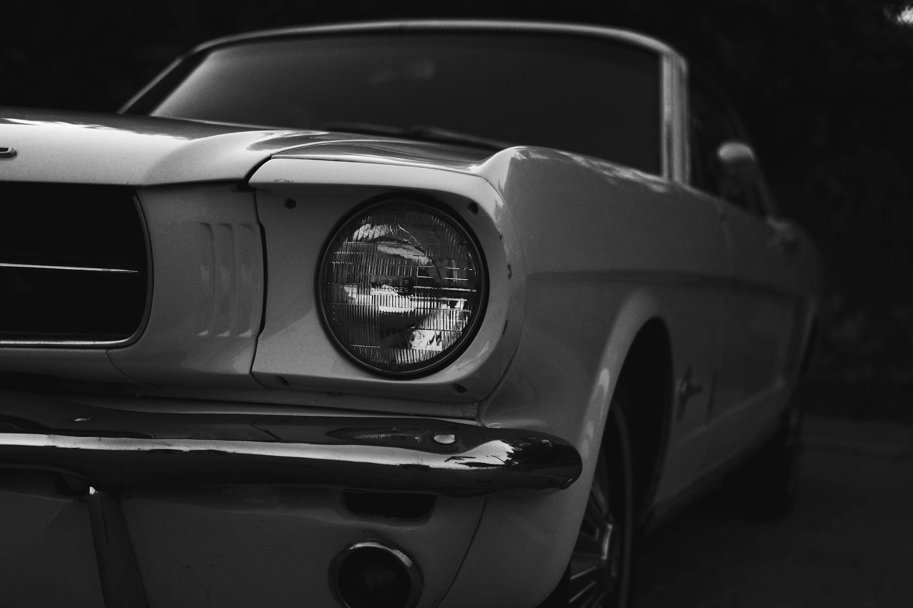 Czarno-białe zbliżenie przednich reflektorów zabytkowego Forda Mustang