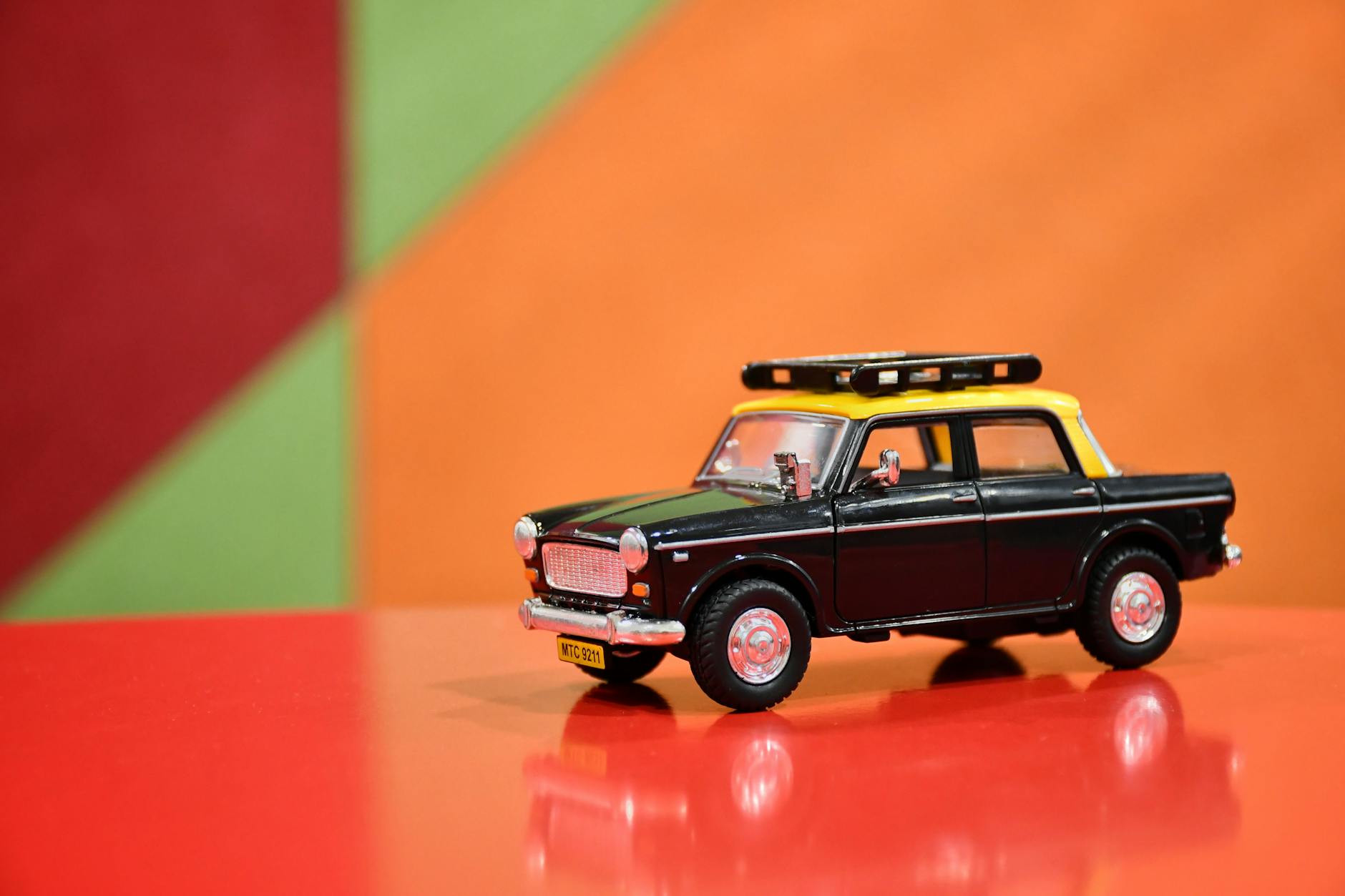 Model czarnej zabytkowej taksówki na kolorowym tle