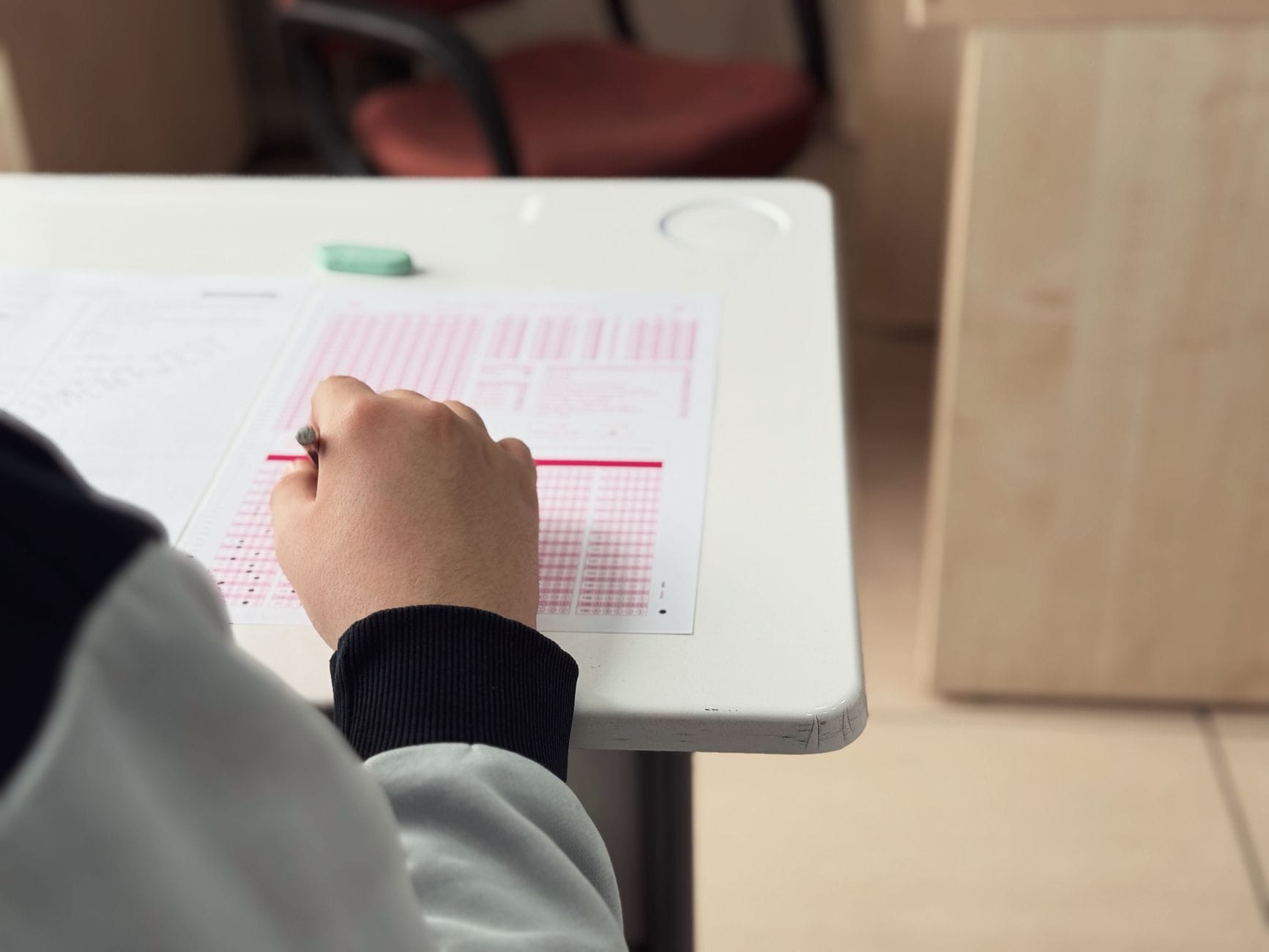 Jak skutecznie przygotować się do egzaminu praktycznego w zawodzie technicznym w Białymstoku Uczeń w klasie wypełnia test egzaminacyjny z przedmiotu technicznego